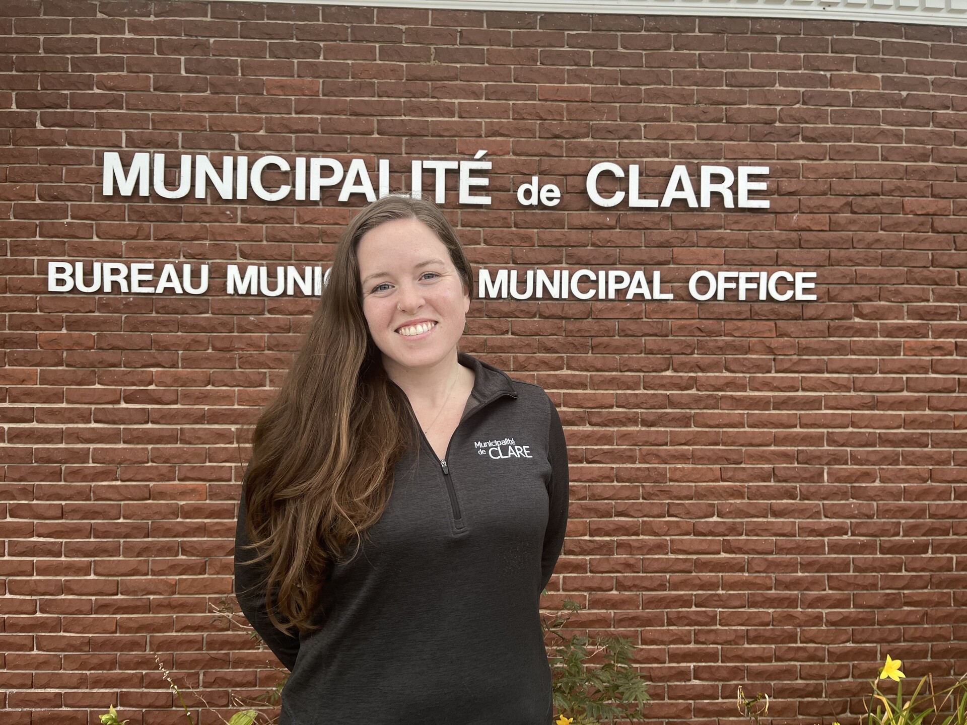 A photo of Jessica Martin, new manager of Clare Recreation Services, in front of the municipal office.