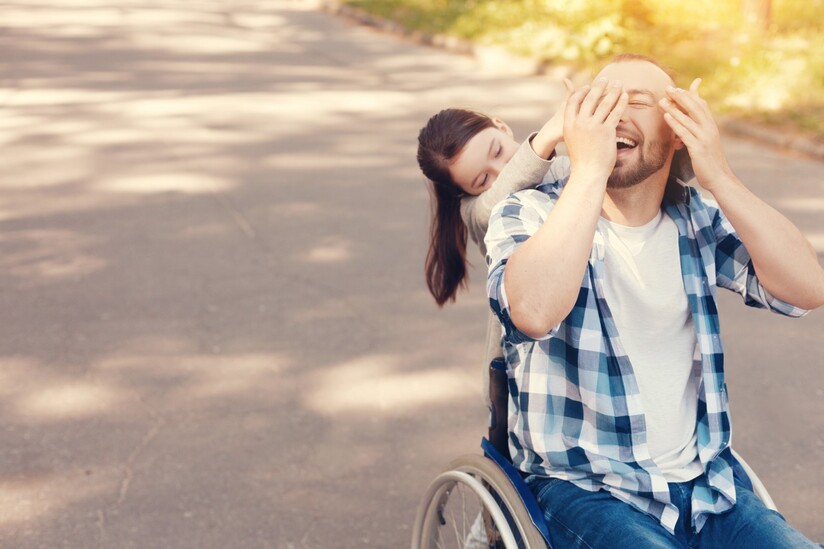 homme en fauteuil roulant avec enfant sur un chemin de gravier